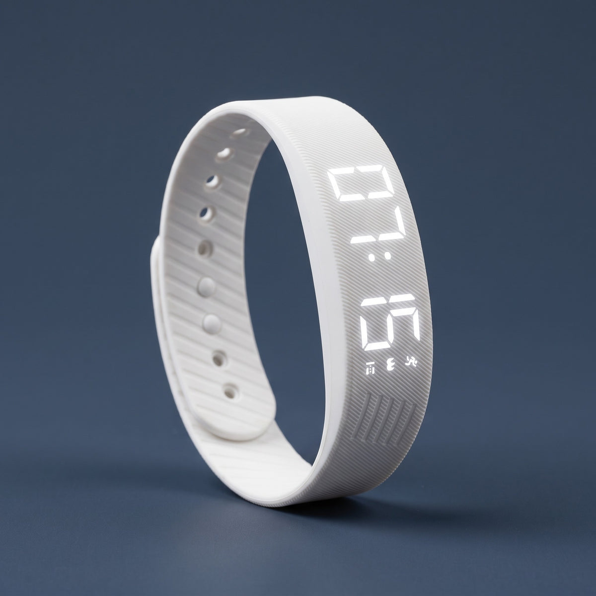 White vibrating alarm band, LED display lit at 07:15.
